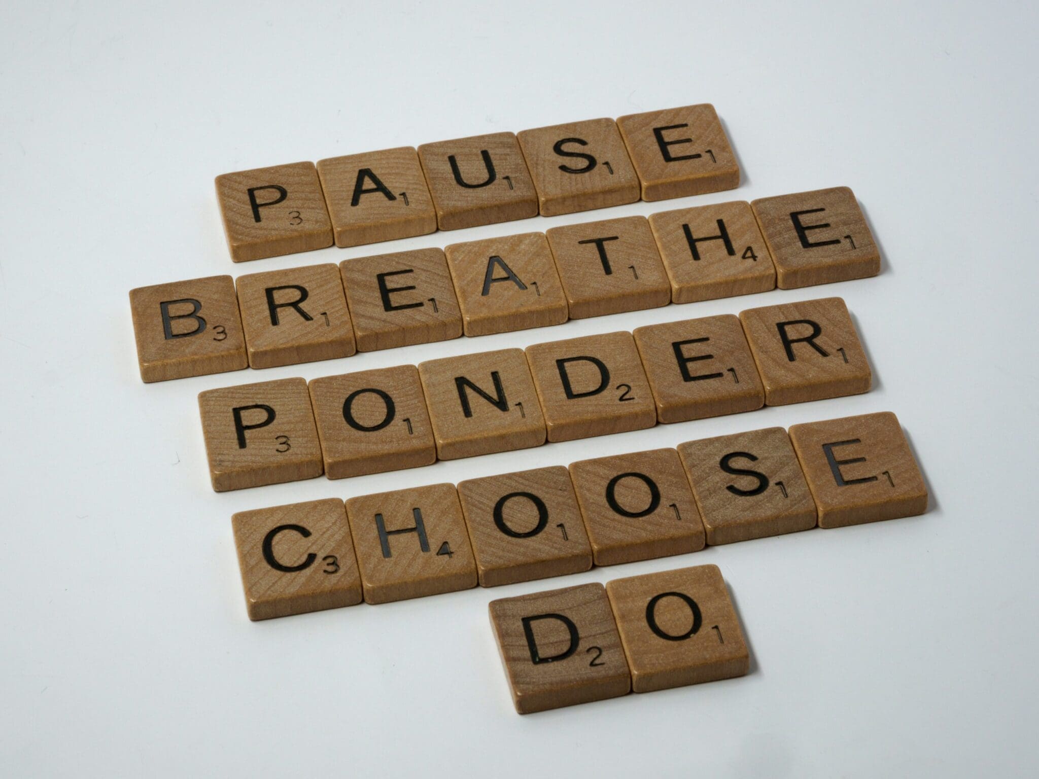 Scrabble tiles spelling "pause breathe ponder choose do"