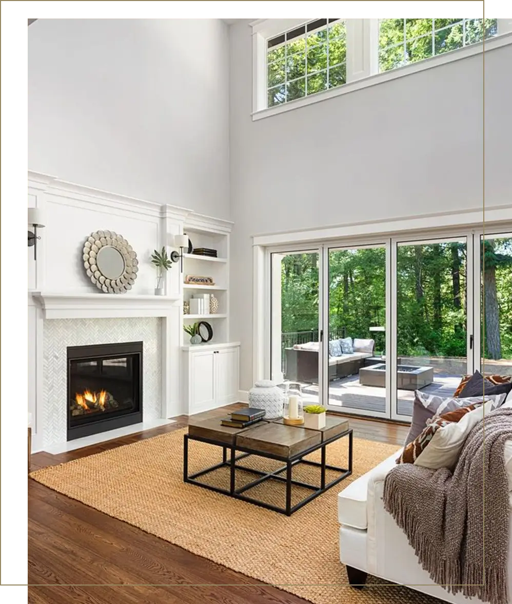 A living room with a fireplace and large windows.