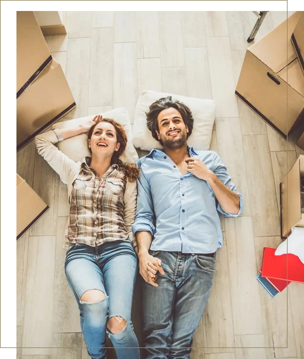 A man and woman laying on the floor in front of boxes.