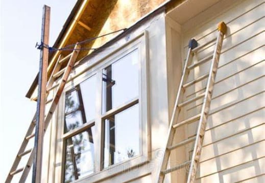 A ladder leaning up against the side of a house.